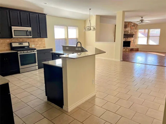 a kitchen with stainless steel appliances kitchen island granite countertop a refrigerator and a stove top oven