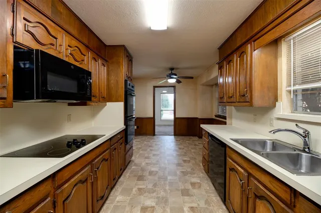 a kitchen with stainless steel appliances a sink a stove and cabinets