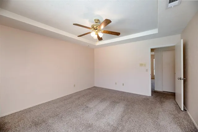 an empty room with closet and a ceiling fan