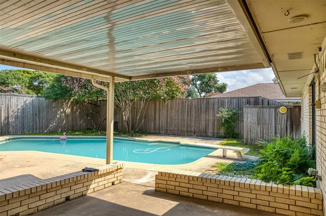a view of a backyard with a table and chair with wooden fence