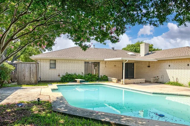 a view of a house with pool and chairs