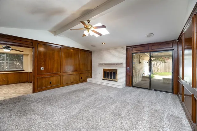 a view of an empty room with a fireplace and a window