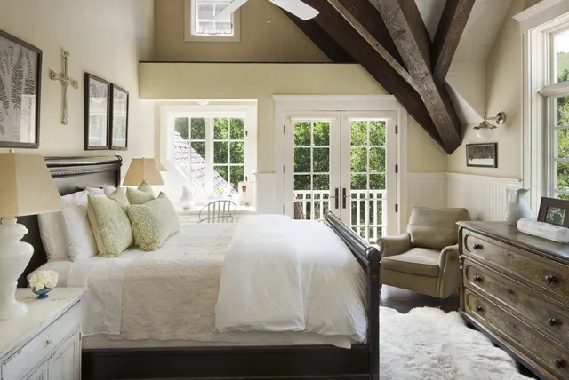 a bed sitting in a bedroom next to a large window