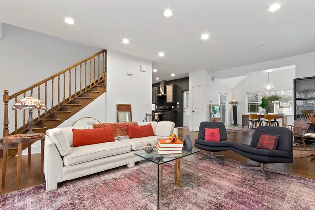 a living room with furniture and a dining table with wooden floor