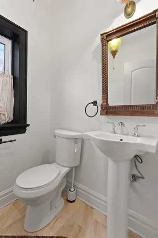 a bathroom with a toilet a sink and mirror