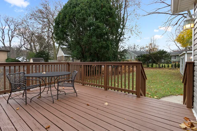 a view of a deck with table and chairs with wooden floor and fence