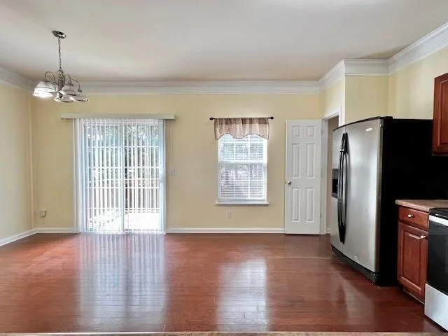 a view of a livingroom with wooden floor and a kitchen