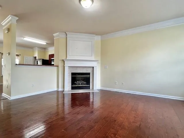 a view of a room with wooden floor and a fireplace