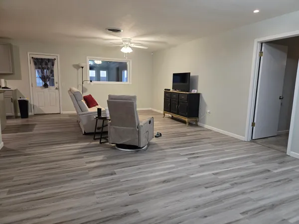 a living room with furniture flat screen tv and wooden floor