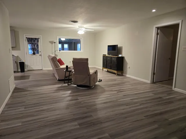 a living room with furniture and a wooden floor