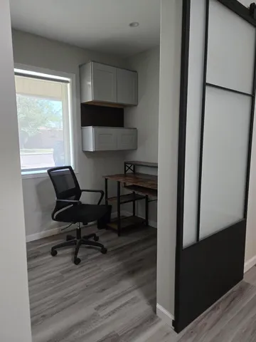 a view of a workspace with furniture and a window