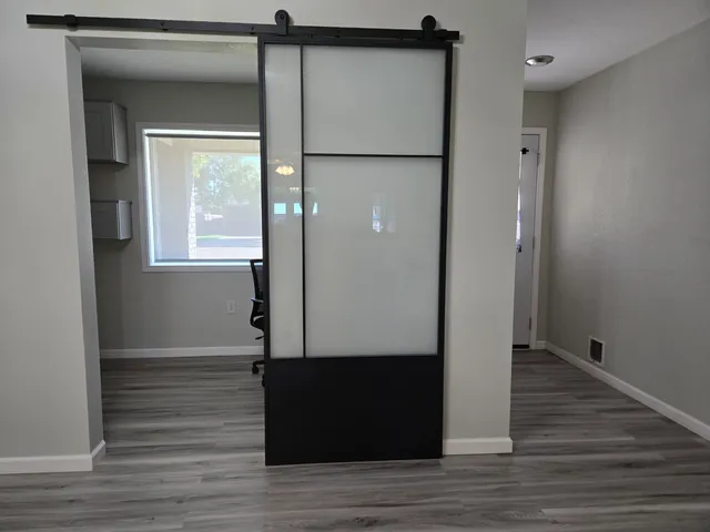 a view of empty room with wooden floor