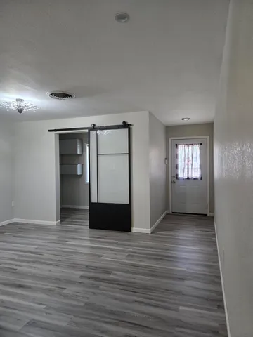 a view of empty room with wooden floor and window