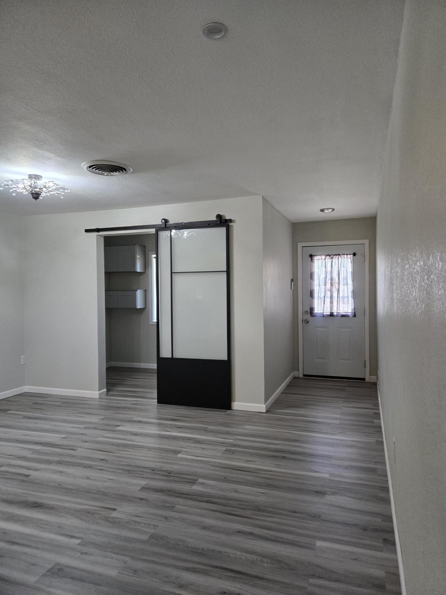 216 North 24th Street Lamesa, TX 79331 - Photo 8 of 27 a view of empty room with wooden floor and window