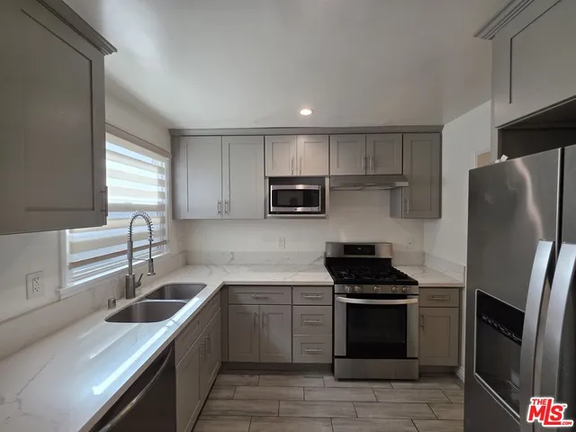 a kitchen with stainless steel appliances granite countertop a stove sink microwave and refrigerator