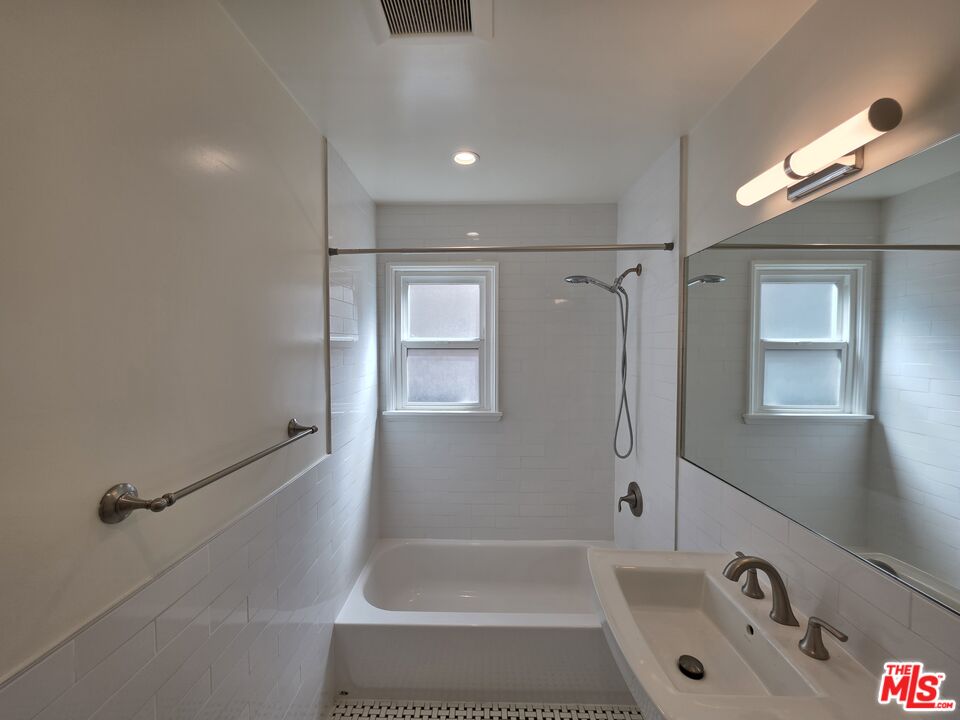 102 Gaviota Avenue, Unit 104 Long Beach, CA 90802 - Photo 18 of 42 a bathroom with a tub a sink and a large mirror