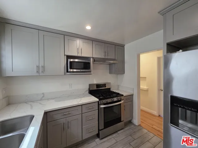 a kitchen with stainless steel appliances a stove a sink and a refrigerator