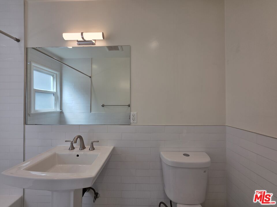 102 Gaviota Avenue, Unit 104 Long Beach, CA 90802 - Photo 24 of 42 a bathroom with a toilet a sink and mirror