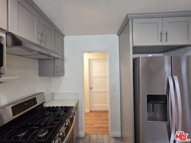 a kitchen with stainless steel appliances granite countertop a refrigerator and a stove top oven