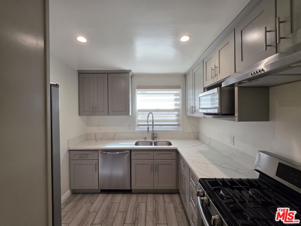 102 Gaviota Avenue, Unit 104 Long Beach, CA 90802 - Photo 4 of 42 a kitchen with granite countertop stainless steel appliances cabinets a sink and a window