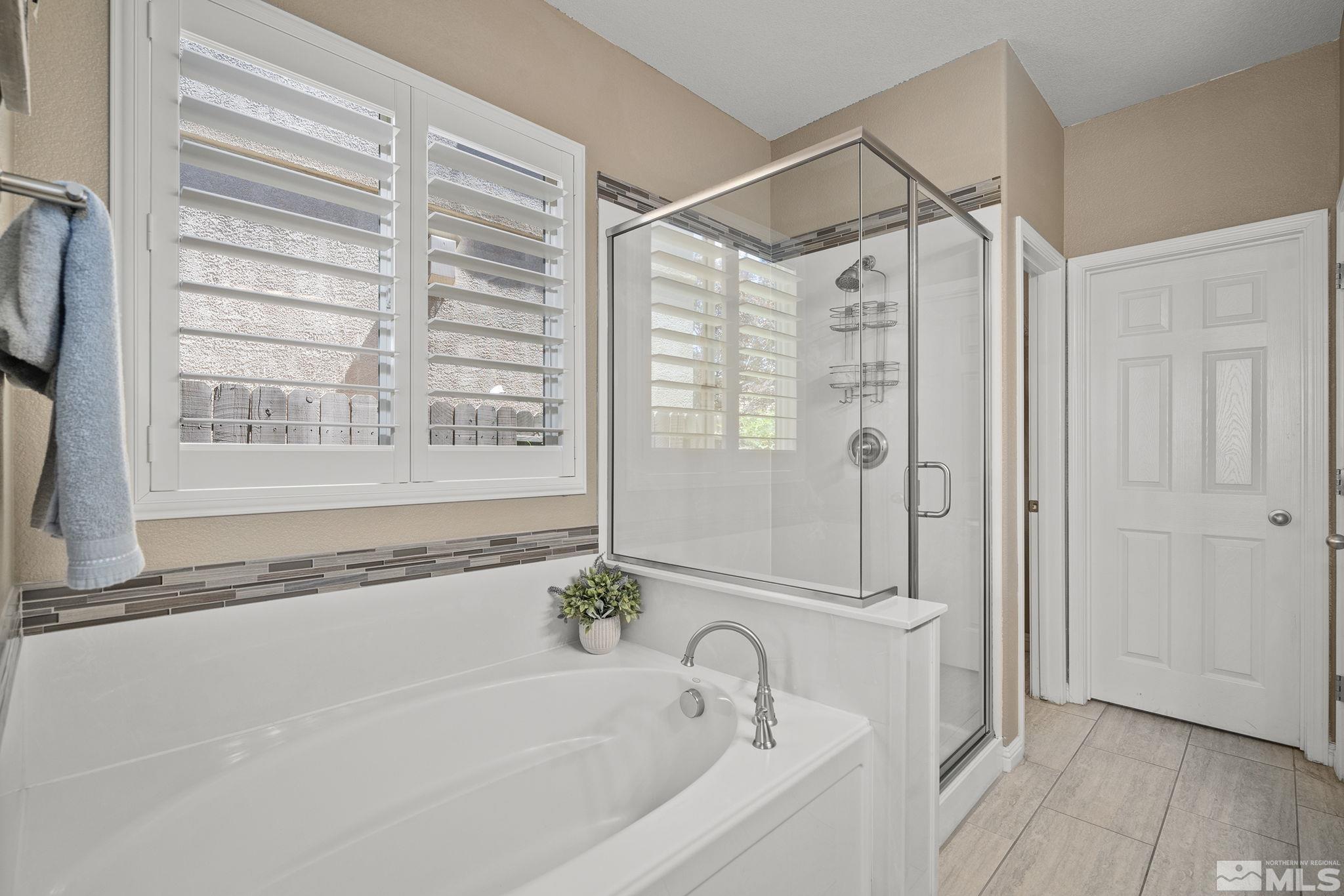 2075 Peaceful Valley Drive Reno, NV 89521 - Photo 19 of 31 a bathroom with a granite countertop bathtub a shower and a window