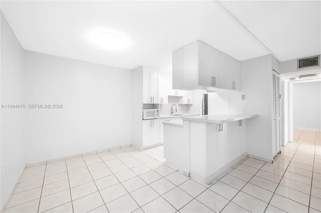 a kitchen with white cabinets a sink and dishwasher