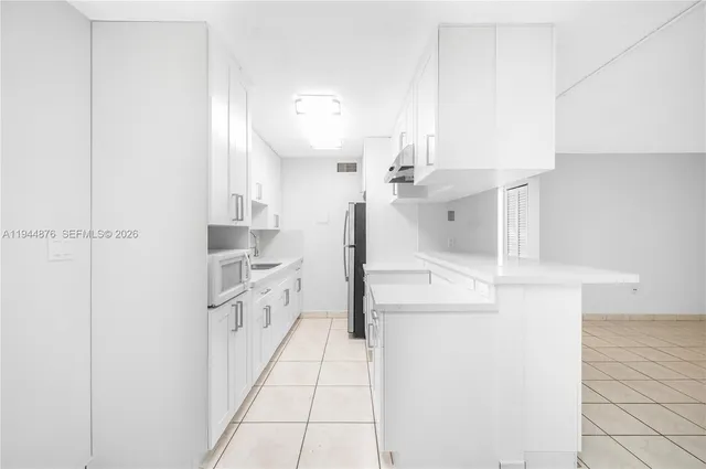 a kitchen with white cabinets and white appliances