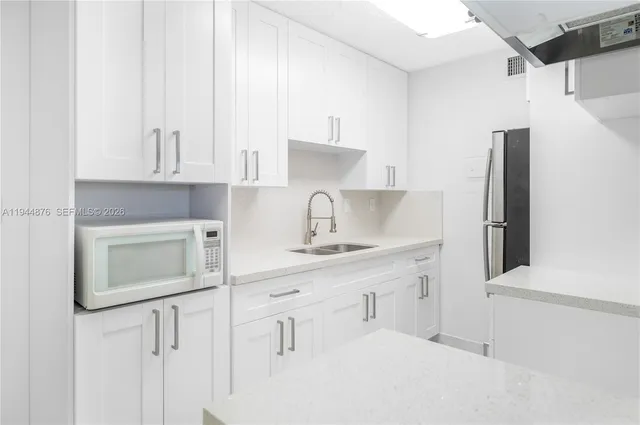 a kitchen with stainless steel appliances white cabinets and a sink