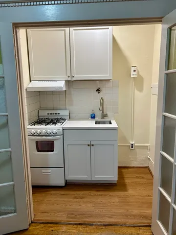 a kitchen with white cabinets and white appliances