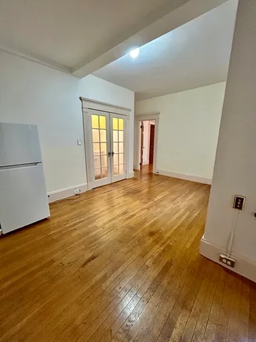 an empty room with wooden floor and window