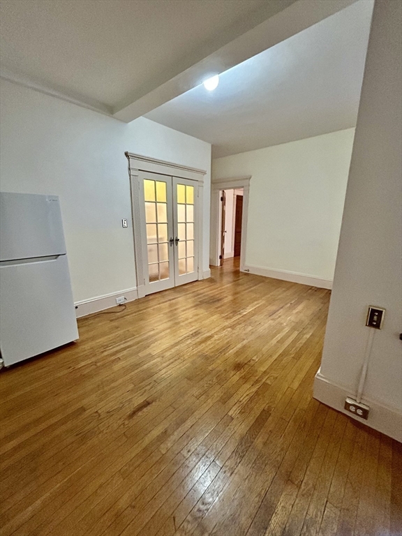8 Garrison Street, Unit 608 Boston, MA 02116 - Photo 5 of 13 an empty room with wooden floor and window