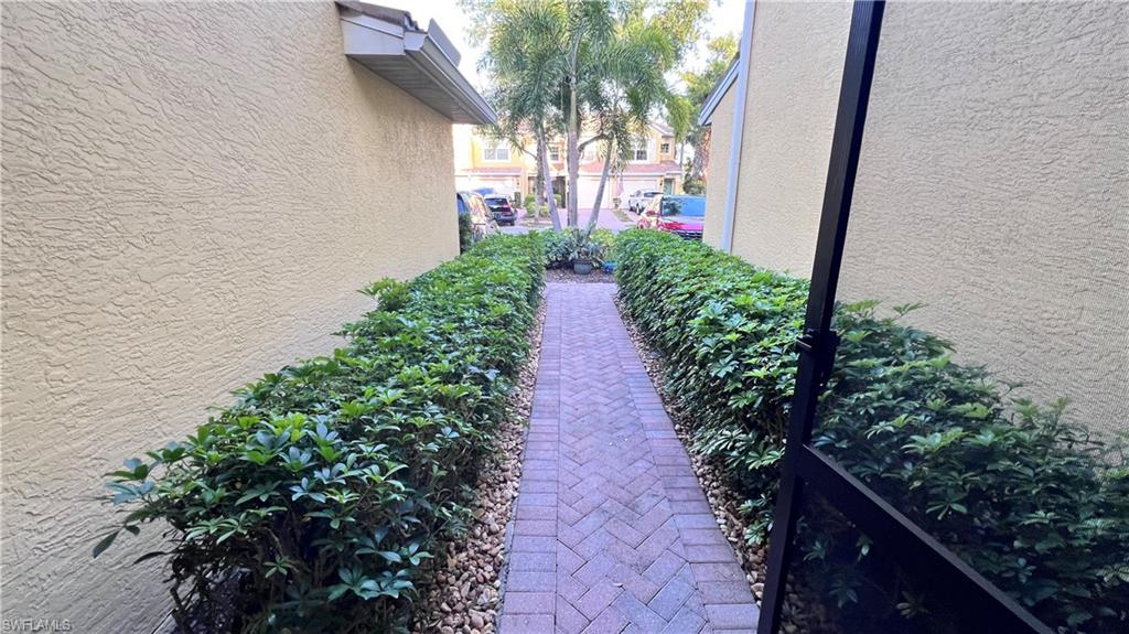 5705 Mayflower Way, Unit 1402 Ave Maria, FL 34142 - Photo 30 of 35 a view of a pathway covered with flower plants