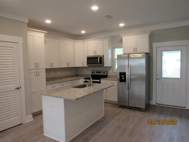 a kitchen with kitchen island a refrigerator sink and microwave