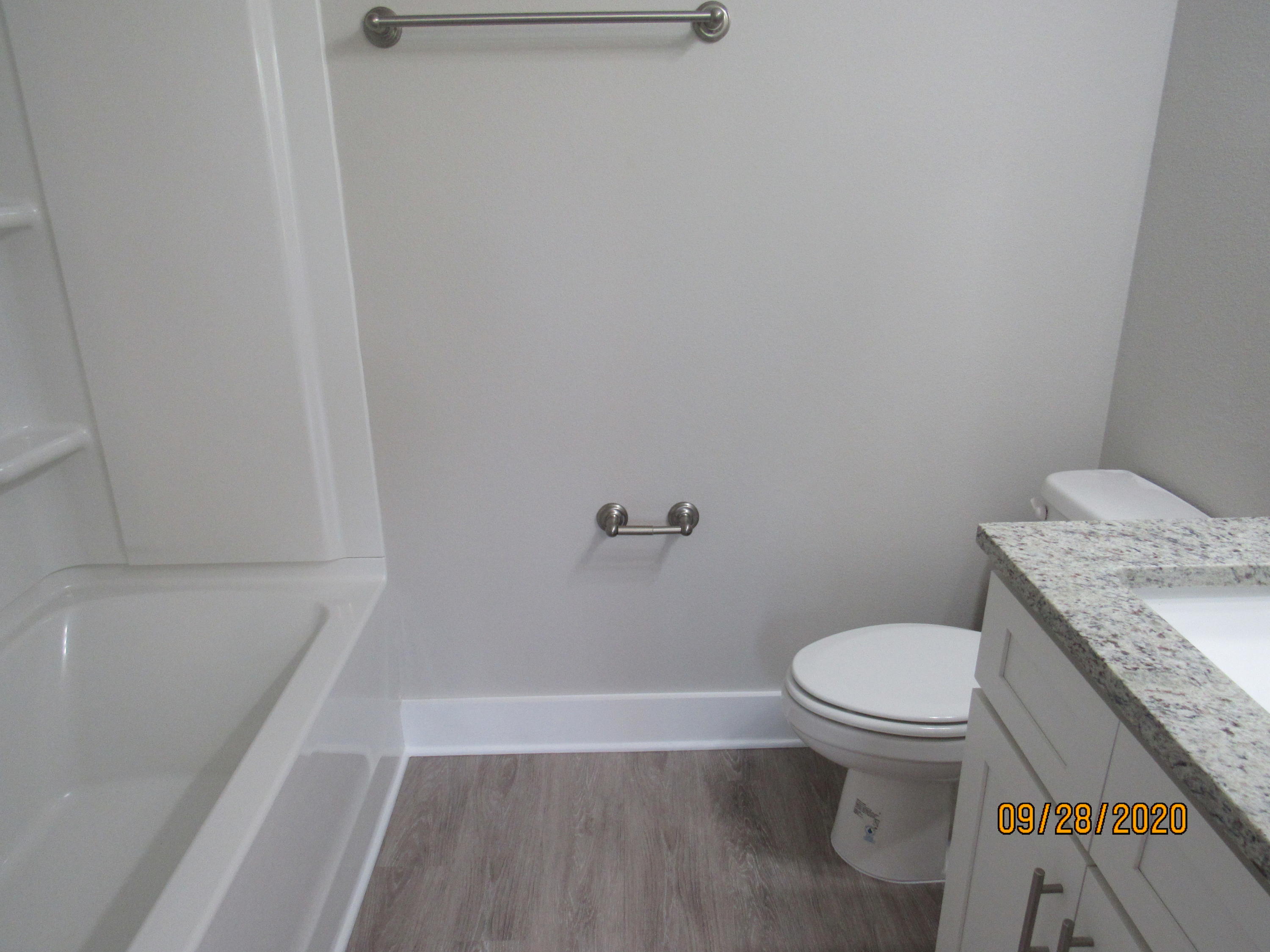 47 South Sand Palm Road Freeport, FL 32439 - Photo 9 of 12 a bathroom with a granite countertop toilet and a tub