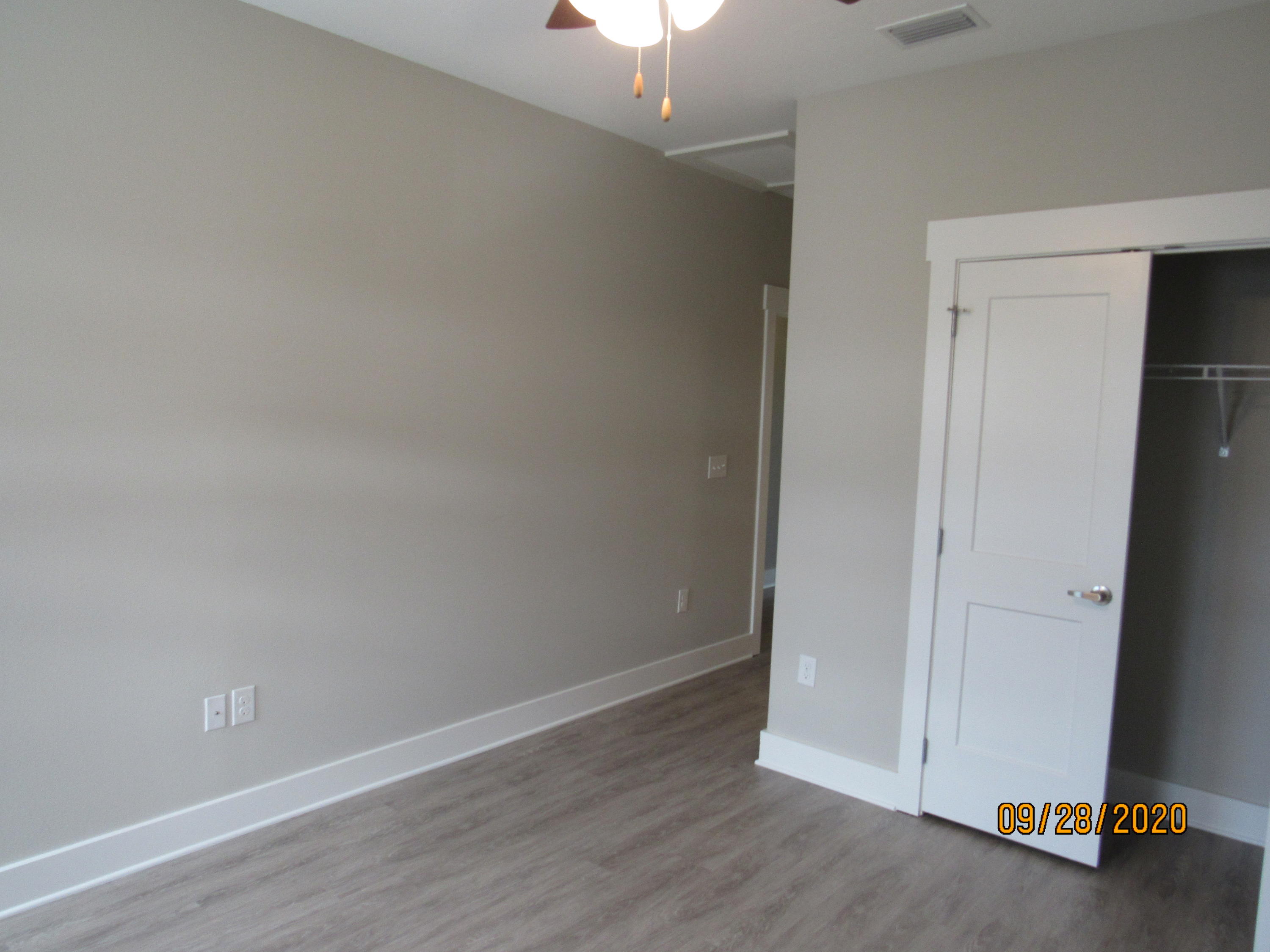 47 South Sand Palm Road Freeport, FL 32439 - Photo 10 of 12 an empty room with wooden floor a ceiling fan and windows