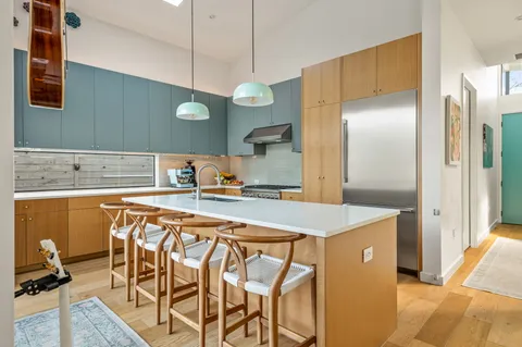 a kitchen with a table a refrigerator and cabinets