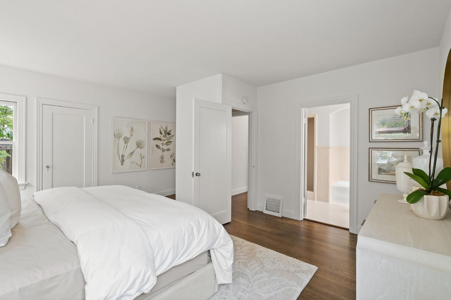 139 Warren Road San Mateo, CA 94401 - Photo 31 of 63 a spacious bedroom with a bed and a potted plant