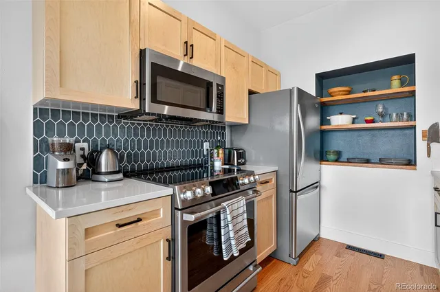 a kitchen with stainless steel appliances granite countertop a refrigerator sink and stove