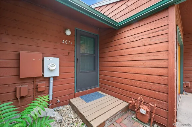 a view of a door and chair in front of house