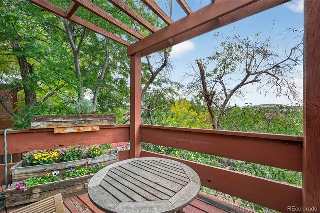 a view of a backyard with wooden fence and large trees
