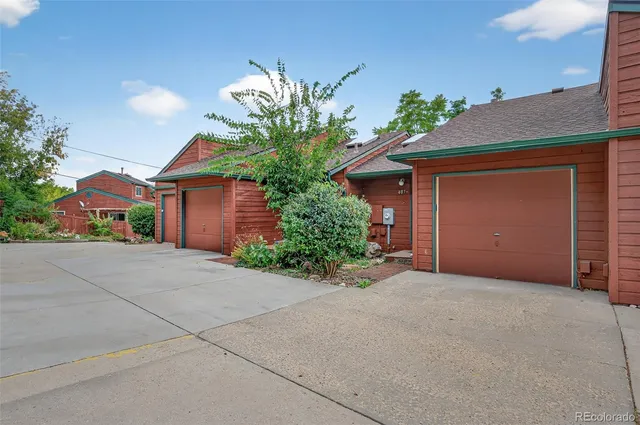 a view of a yard with plants and a bench