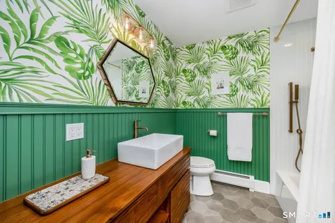 a bathroom with a toilet sink and mirror