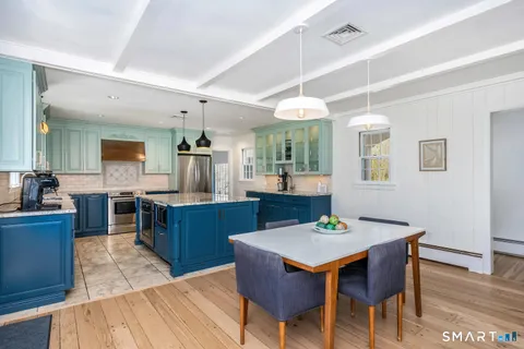 a kitchen with a dining table chairs and wooden floor