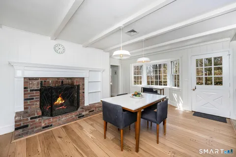 a dining room with a fireplace a table and chairs