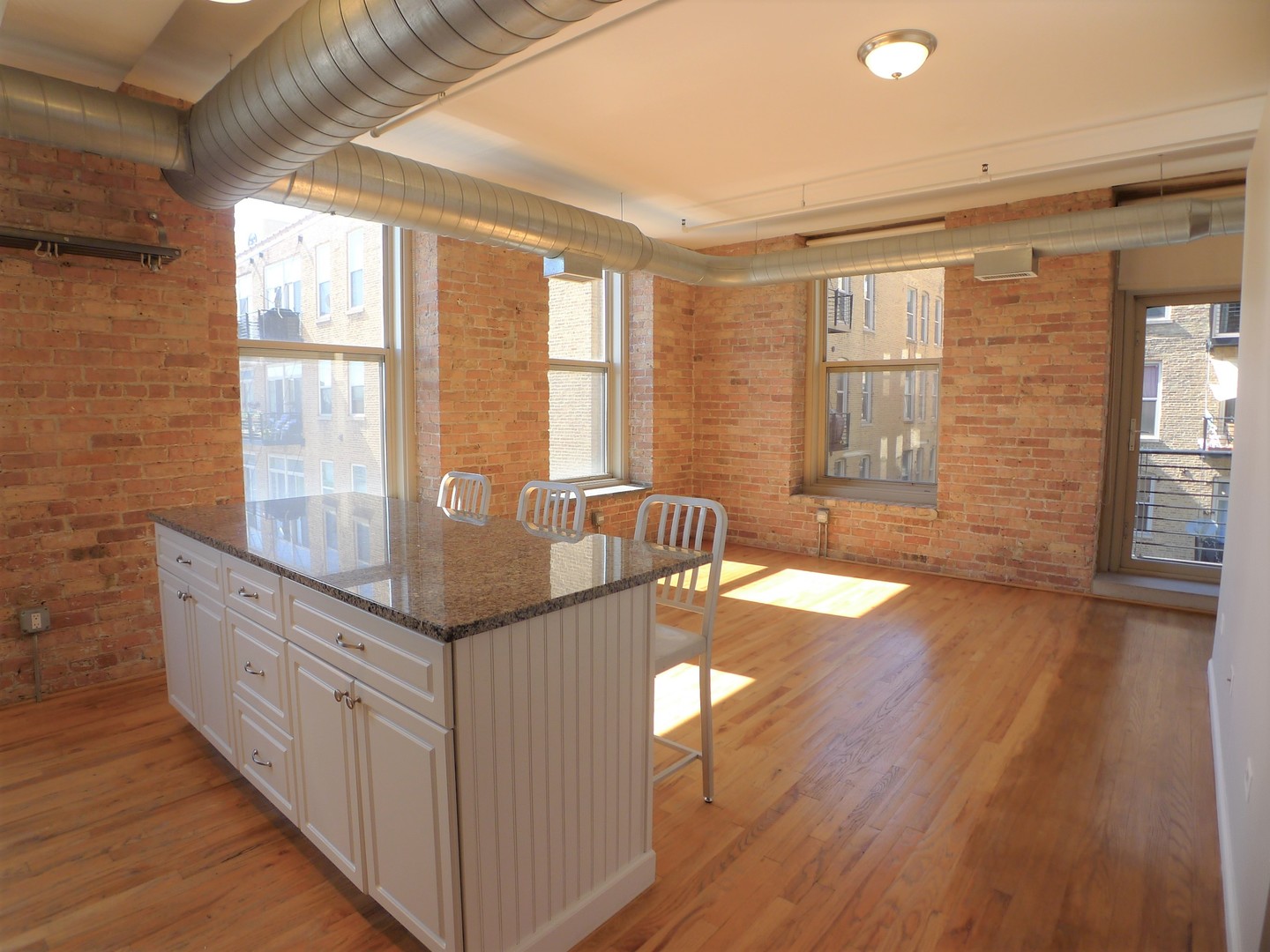 420 South Clinton Street, Unit 401A Chicago, IL 60607 - Photo 3 of 22 a open kitchen with granite countertop a stove top oven a sink with wooden cabinets and floor