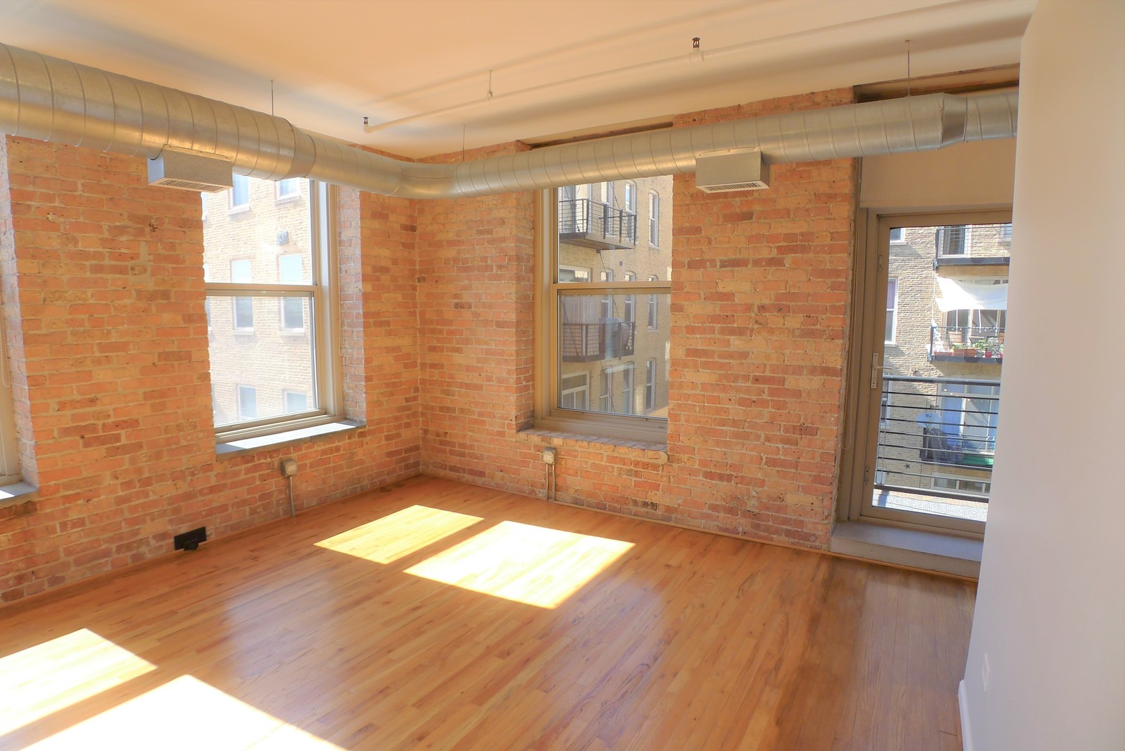 420 South Clinton Street, Unit 401A Chicago, IL 60607 - Photo 5 of 22 a view of an empty room with wooden floor and a window