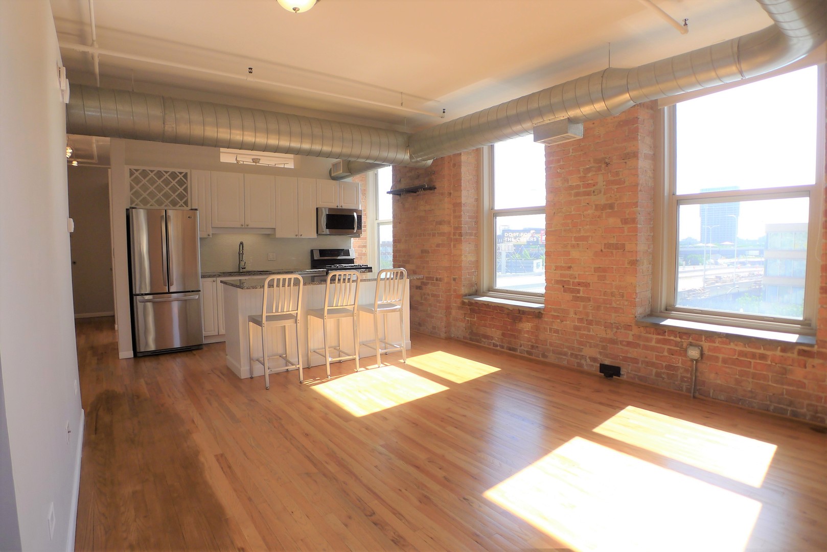 420 South Clinton Street, Unit 401A Chicago, IL 60607 - Photo 6 of 22 a large kitchen with stainless steel appliances wooden floor and a window
