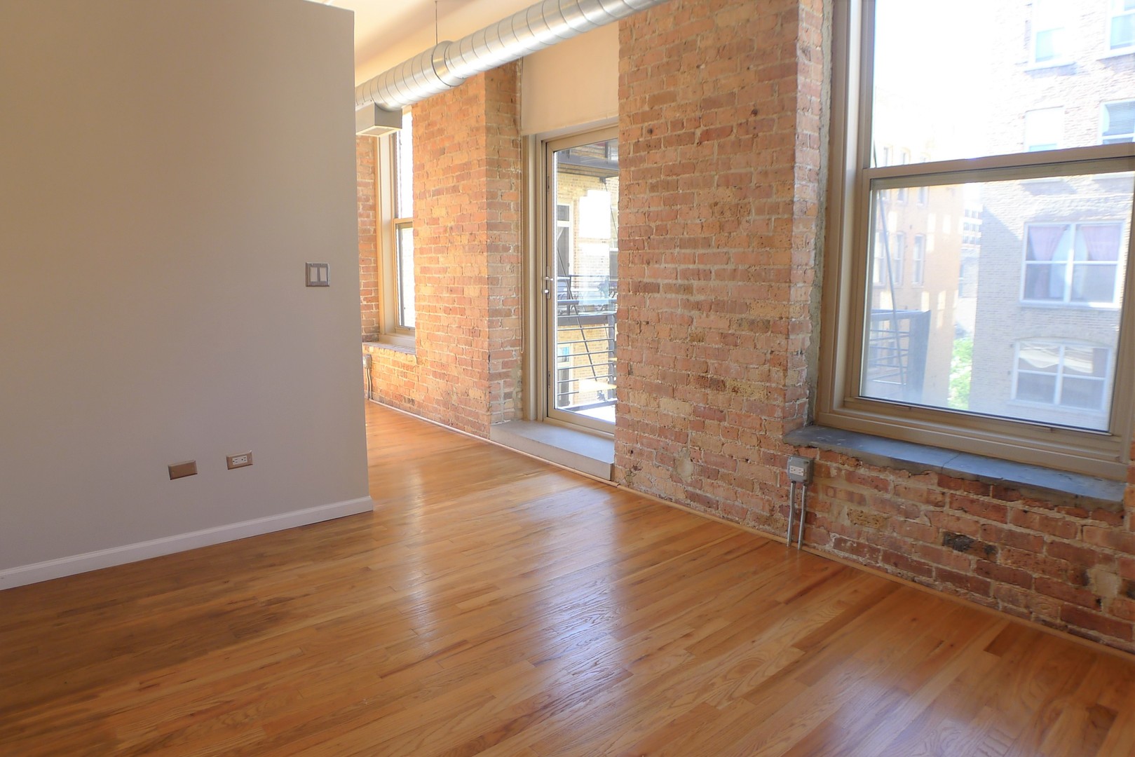 420 South Clinton Street, Unit 401A Chicago, IL 60607 - Photo 9 of 22 a view of an empty room with wooden floor and a window