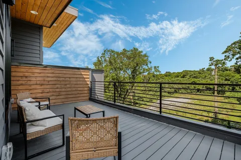a view of a balcony with wooden floor and potted plants