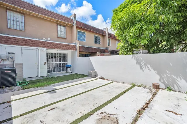 a view of backyard with large tree and wooden fence